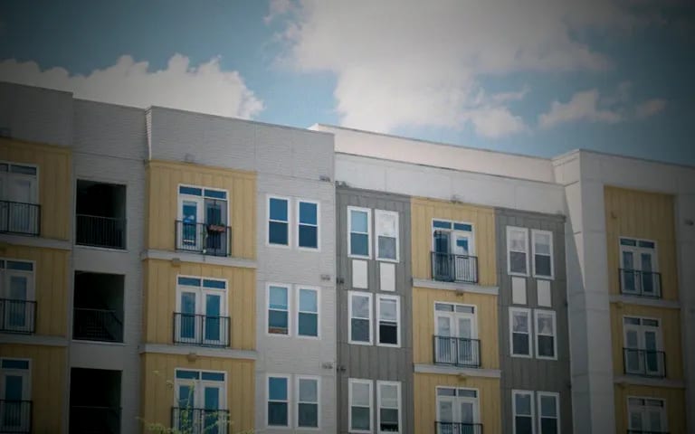 A modern low-rise apartment building under a blue sky