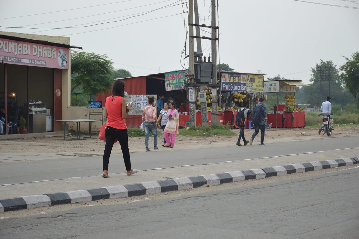 A woman in Punjab, India, texting whilst walking. Banur Kharar Highway, Landran, Mohali