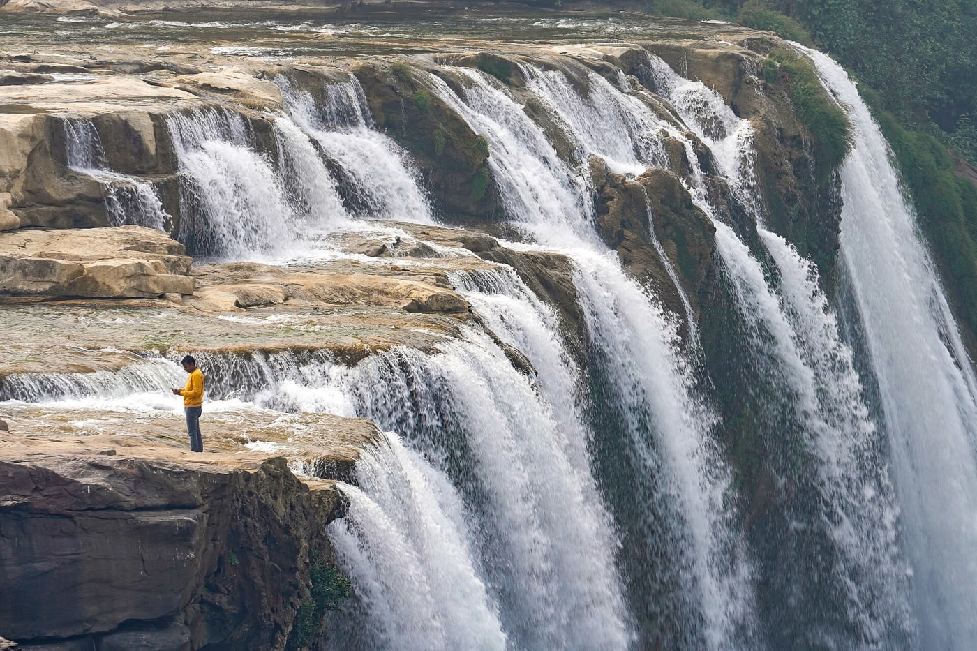 Man uses cellphone at the top of the Keoti Falls, Rewa District, MP, India