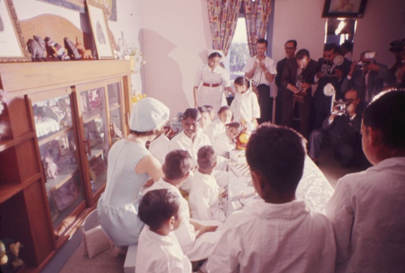 First Lady Jacqueline Kennedy (kneeling at left) visits patients in the children’s ward of the All-India Institute of Medical Sciences in Ne
