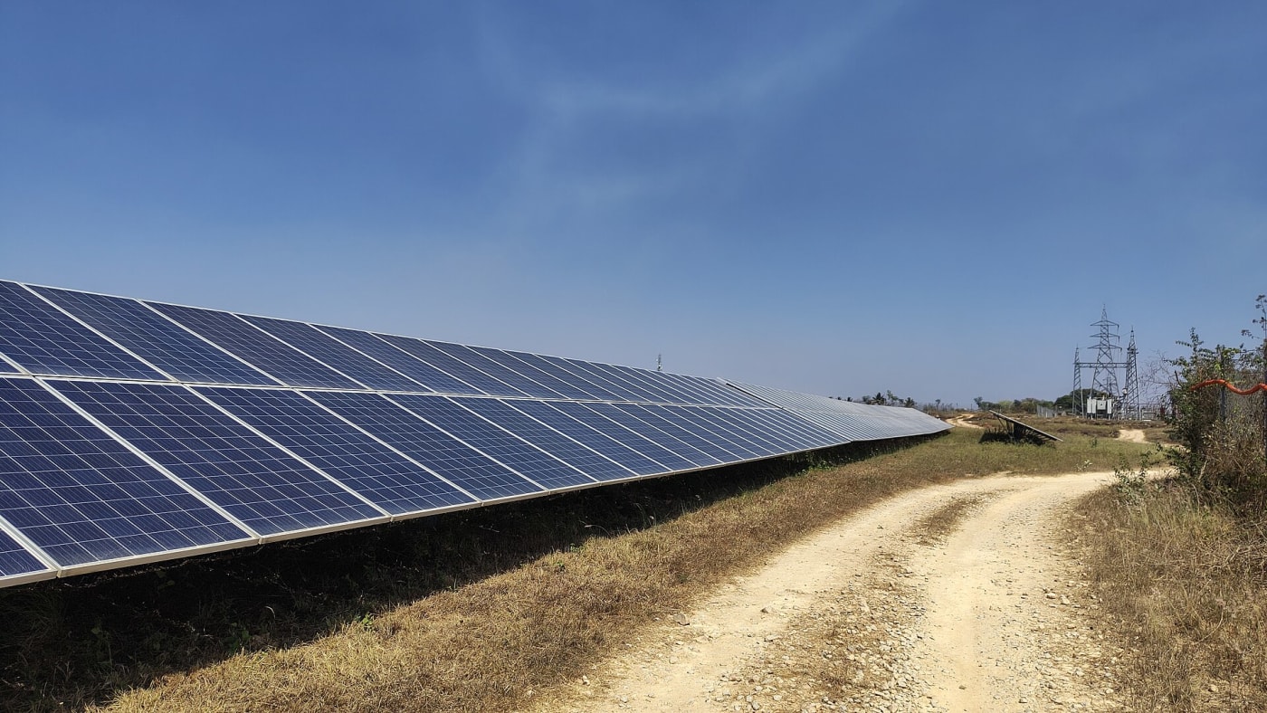 Solar panels in India with electric grid behind