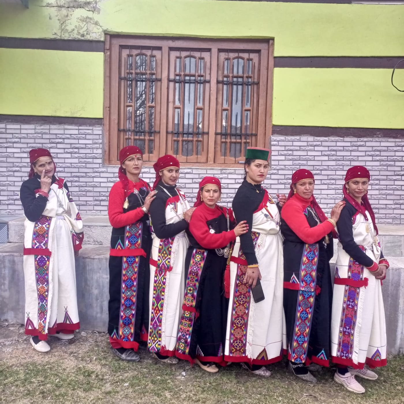 This photograph shows women members of a Mahila Mandal dressed in traditional Kullvi Pattu, a woolen wrap commonly worn by women in the Kull
