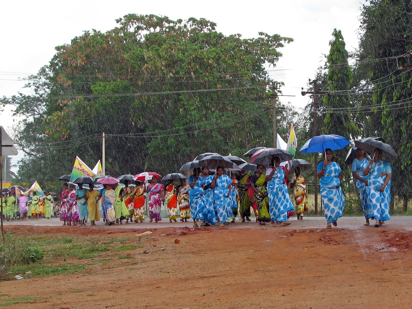Self Help Group women in rural Kanchipuram showing them solidarity, and pride in group saris and braving the heavy rain to raise awareness o