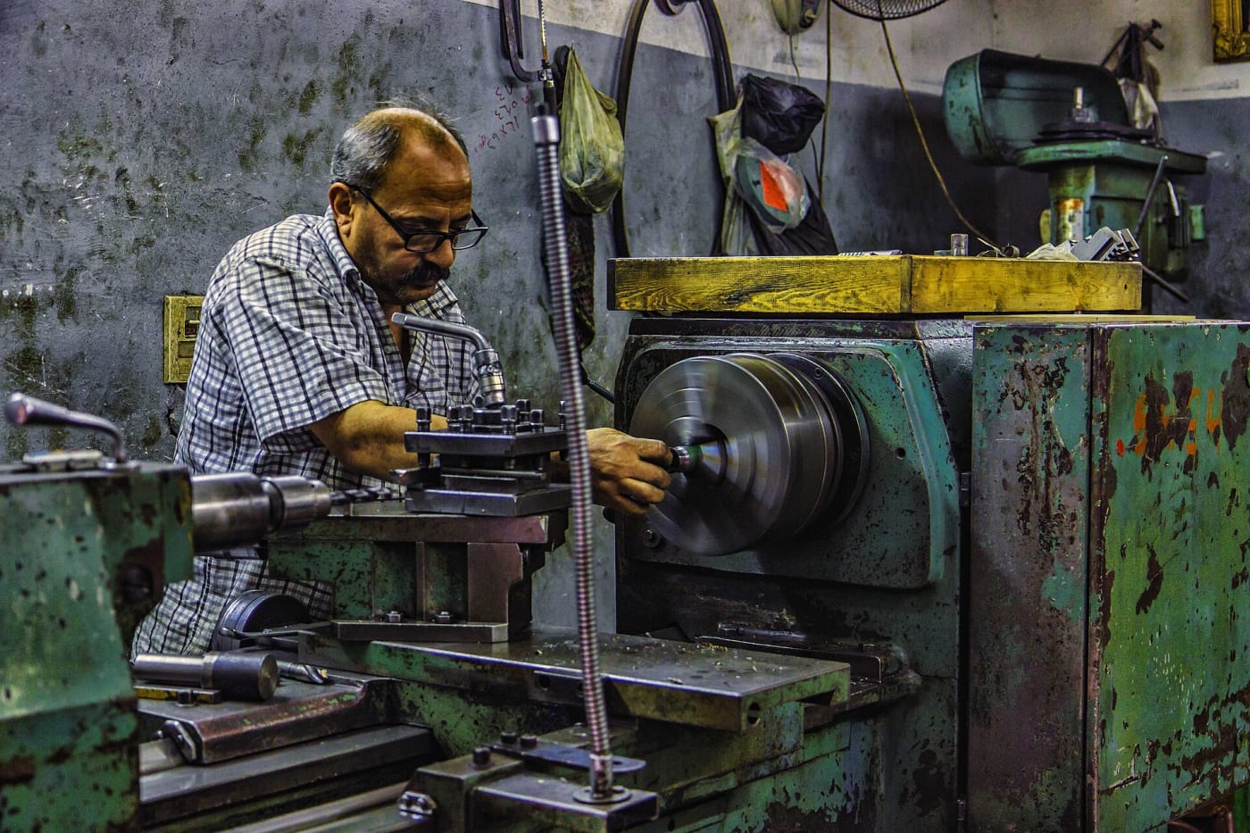 A man forming metal at a workshop
