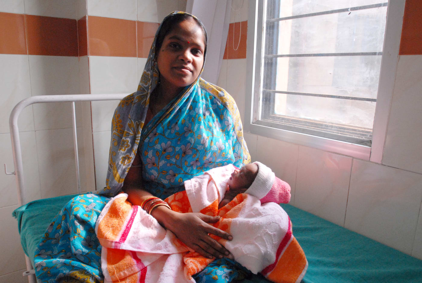A mother with her newborn baby in a hospital ward in Odisha.