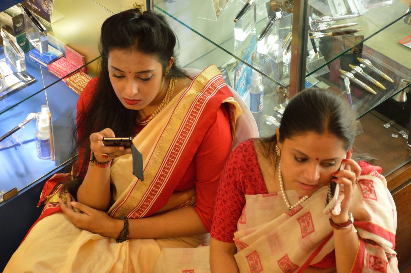 Two women using mobile phones in Kolkata, West Bengal.