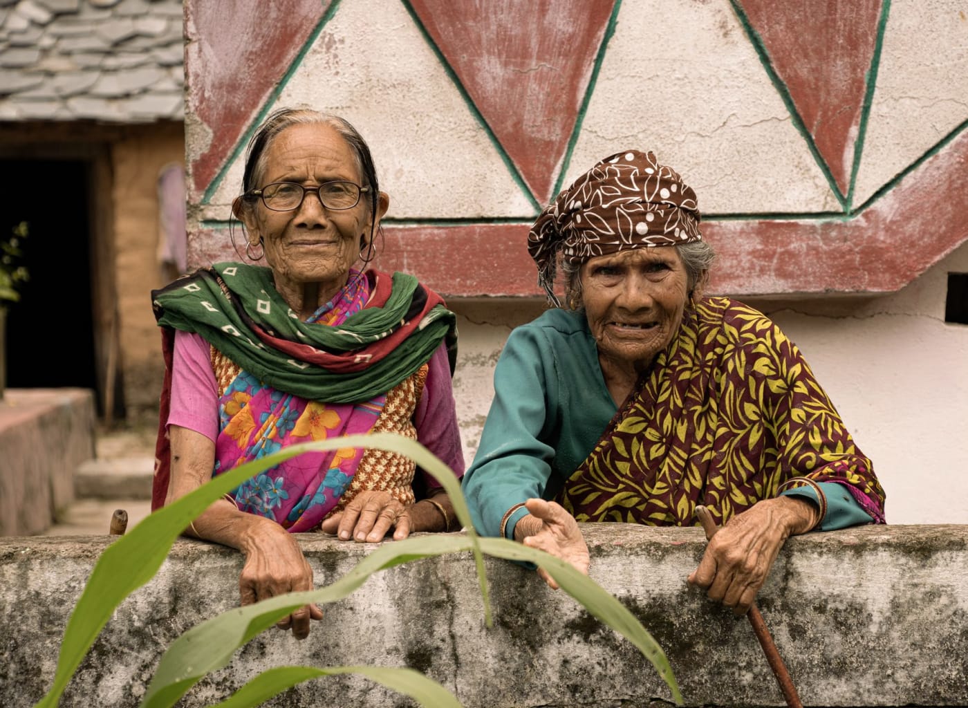 Two senior women in colourful traditional dress, smiling, in India.