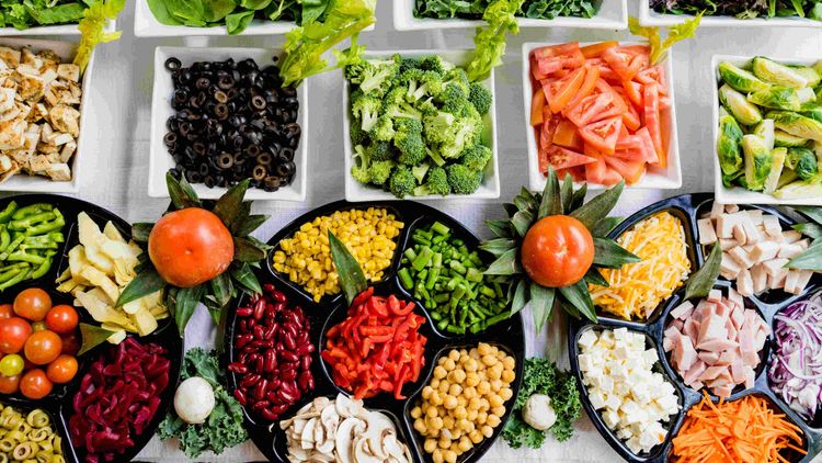 spread of different types of multicoloured vegetables on plates and square platters