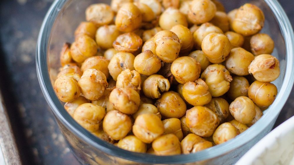 chickpeas in a glass bowl on a black surface