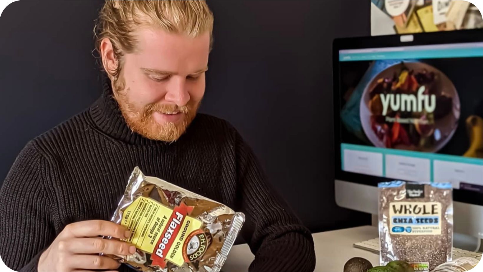 Plant-based nutritionist Callum Weir smiling while holding a bag of flaxseeds 