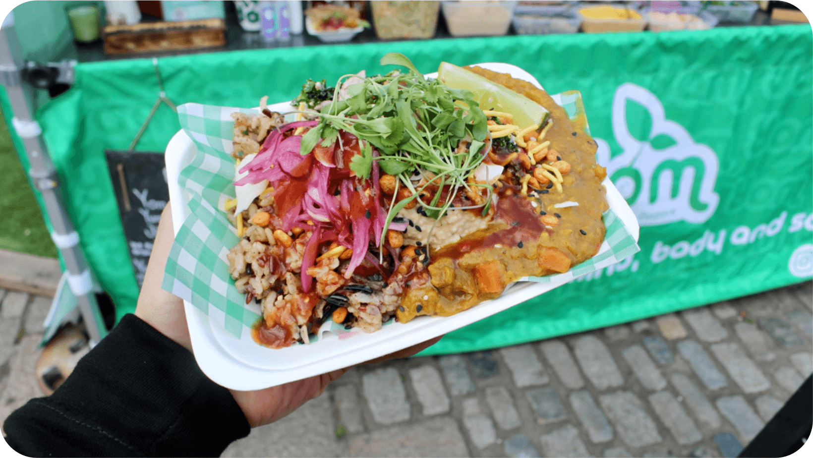 Man holding a colourful tray full of Middle Eastern street food, from Jordan Pomerance’s pop-up restaurant Yom