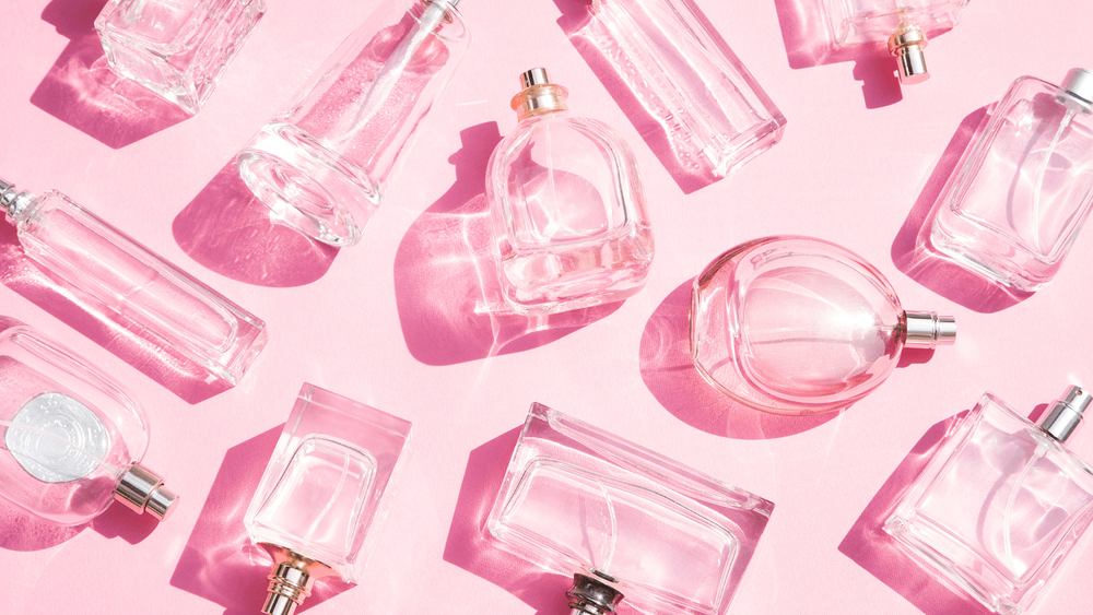 Bottles by vegan perfume brands on a pink background