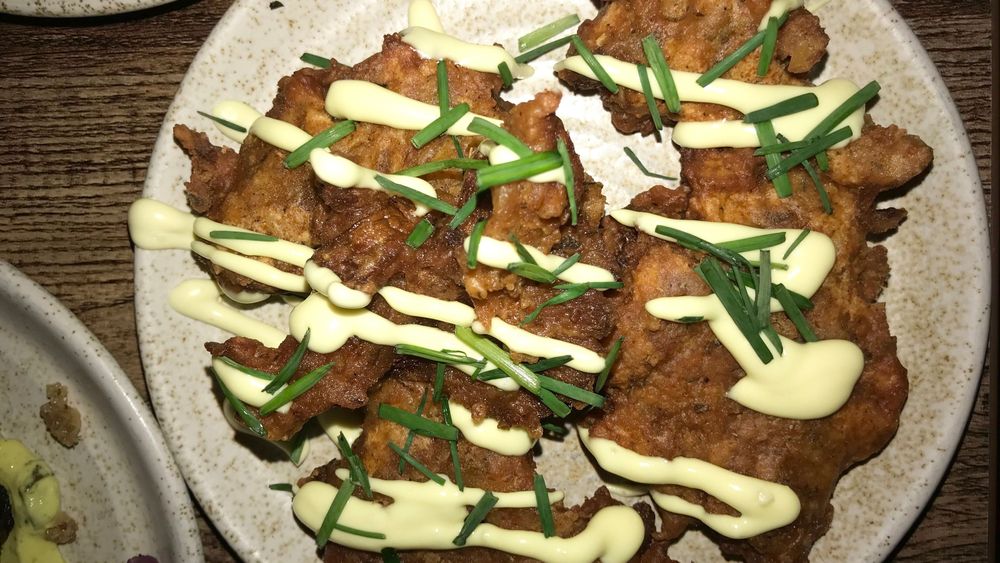 Koocha Mezze Bar’s deep fried oyster mushroom wings with sauce dribbled over it