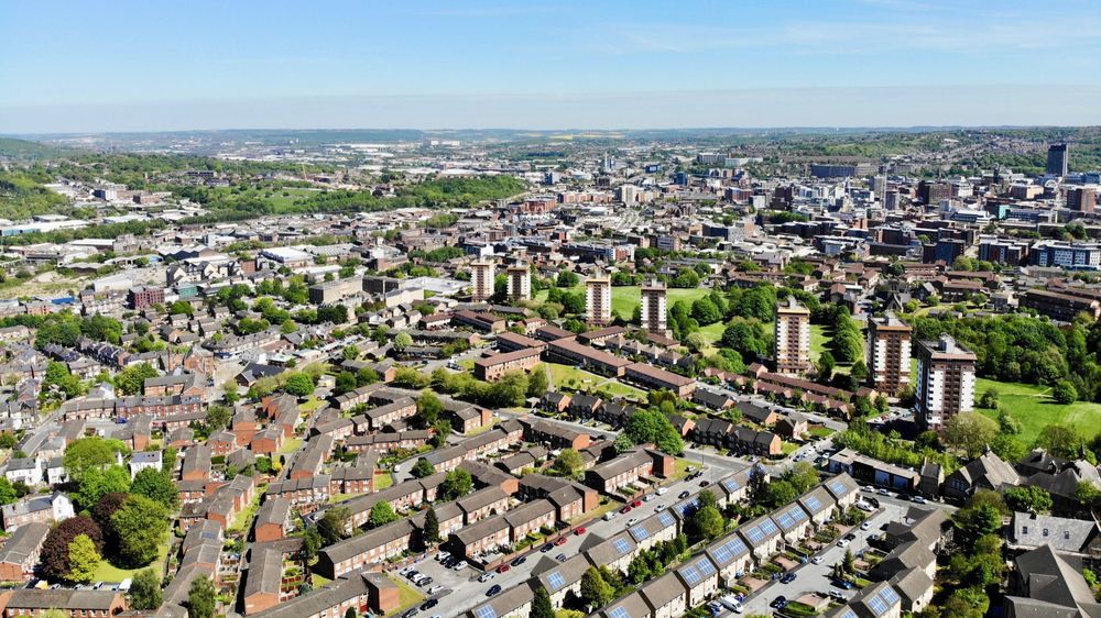 Aerial view of Sheffield: the greenest city in the UK with a variety of high- and low-rise buildings and green spaces and trees