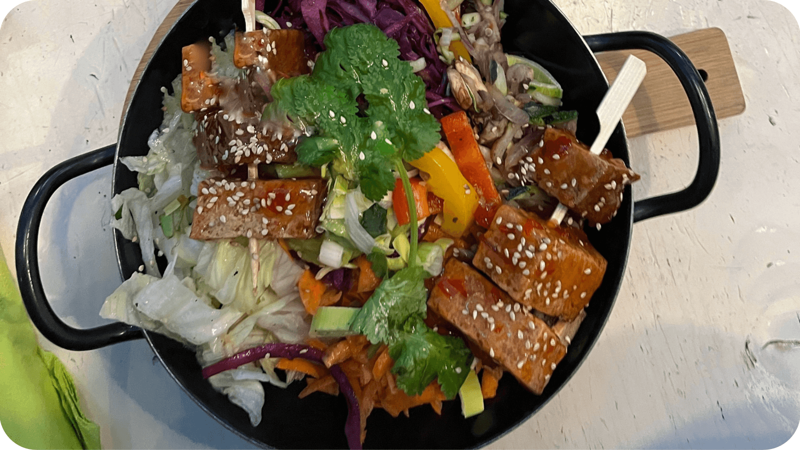 Vegan Buddha bowl full of mixed veg; salad; vegan meat, coriander etc.