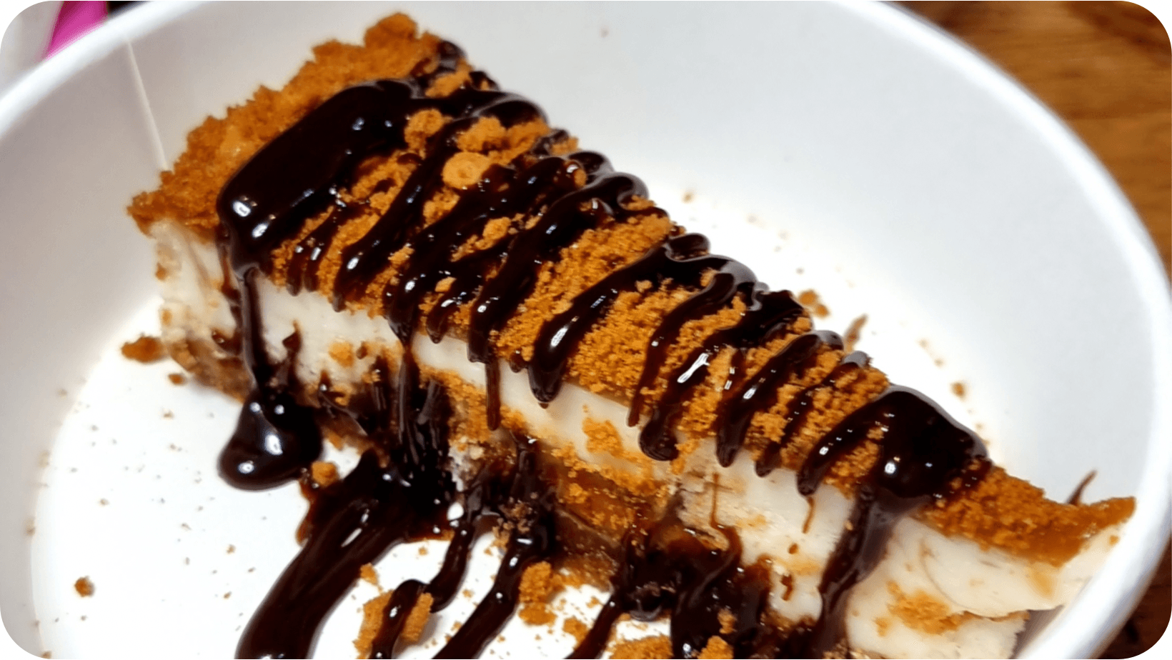 Vegan Noms Brighton Caramelised Biscuit Cake with chocolate sauce topping in a white dish