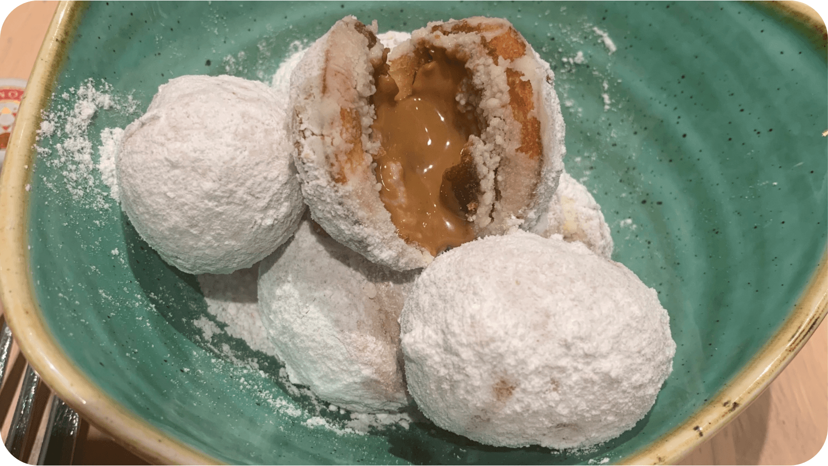 Mini vegan doughnut balls with a gooey Biscoff centre in a blue bowl from Pastan Bristol