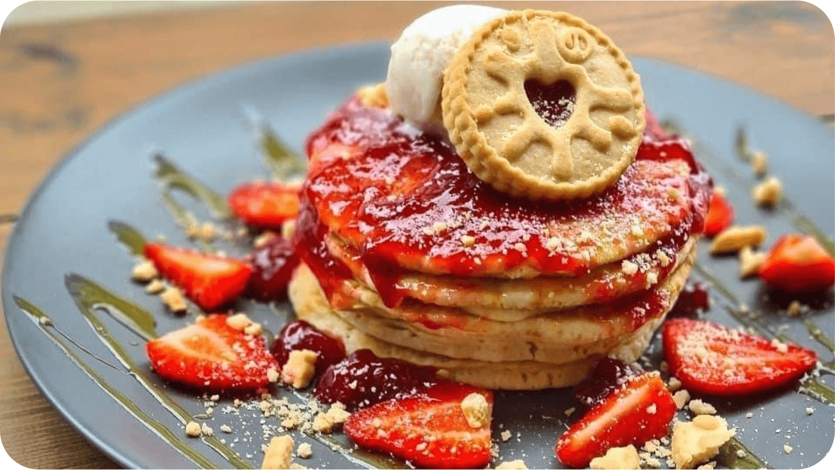 Vegan Jammie Dodger pancakes with ice cream and strawberries on a grey plate from HAMPTON & VOÚIS