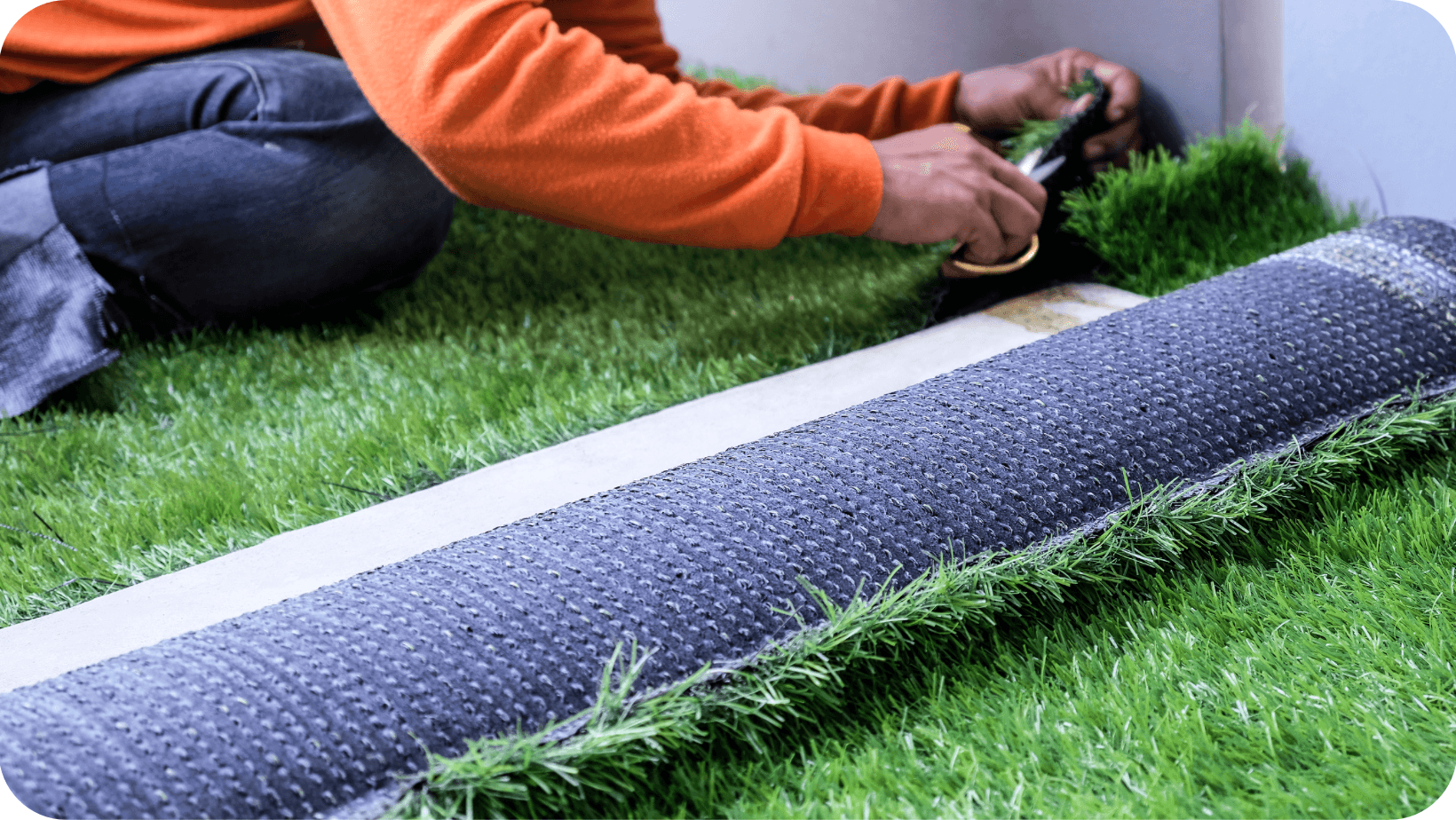 Person cutting and fitting one of their artificial lawns 