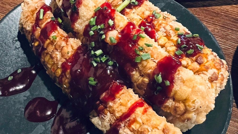 Vegan ‘crispy ribs’ with red sauce and chives on top 