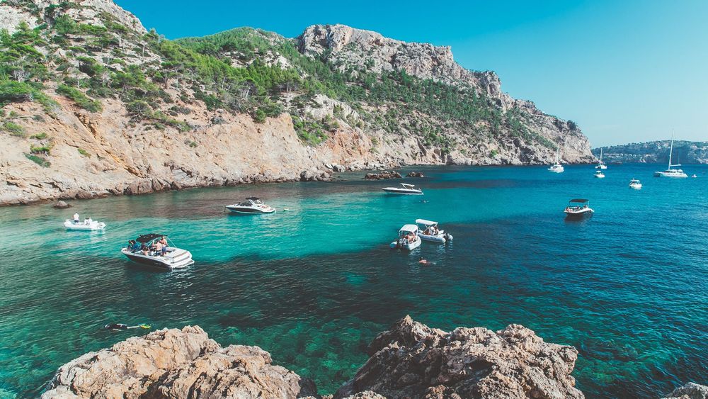 Mallorcan harbour with boats and mountainous cliffs in the background 