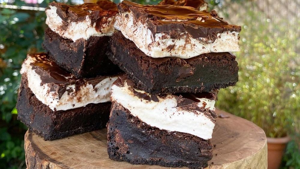 Layered vegan chocolate cakes stacked on top of a wooden table