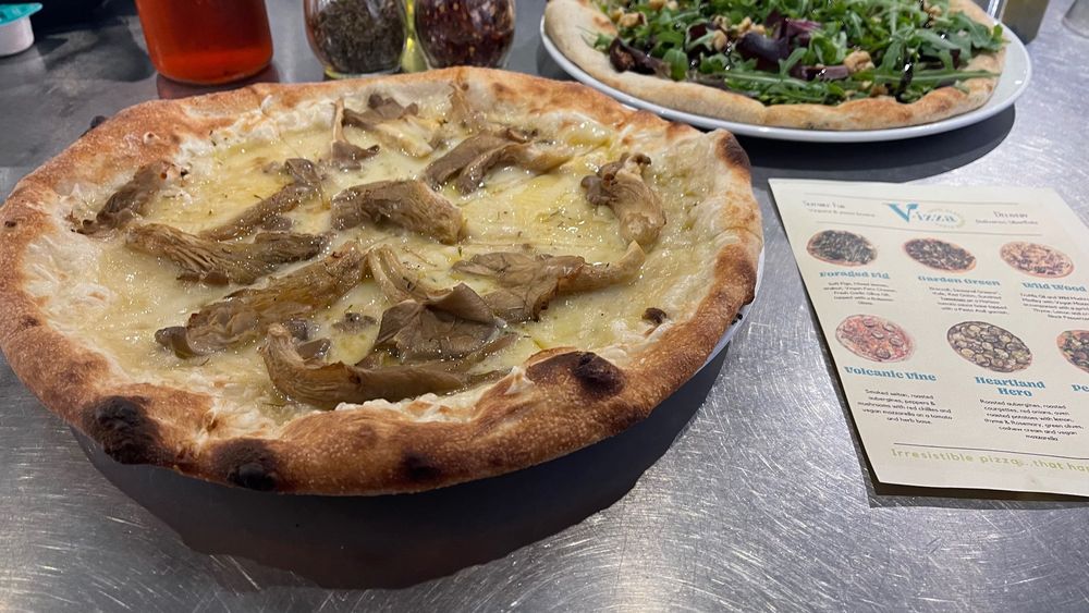 Vegan pizzas from V-izza, one topped with vegan cheese and oyster mushrooms and the other with rocket and onions