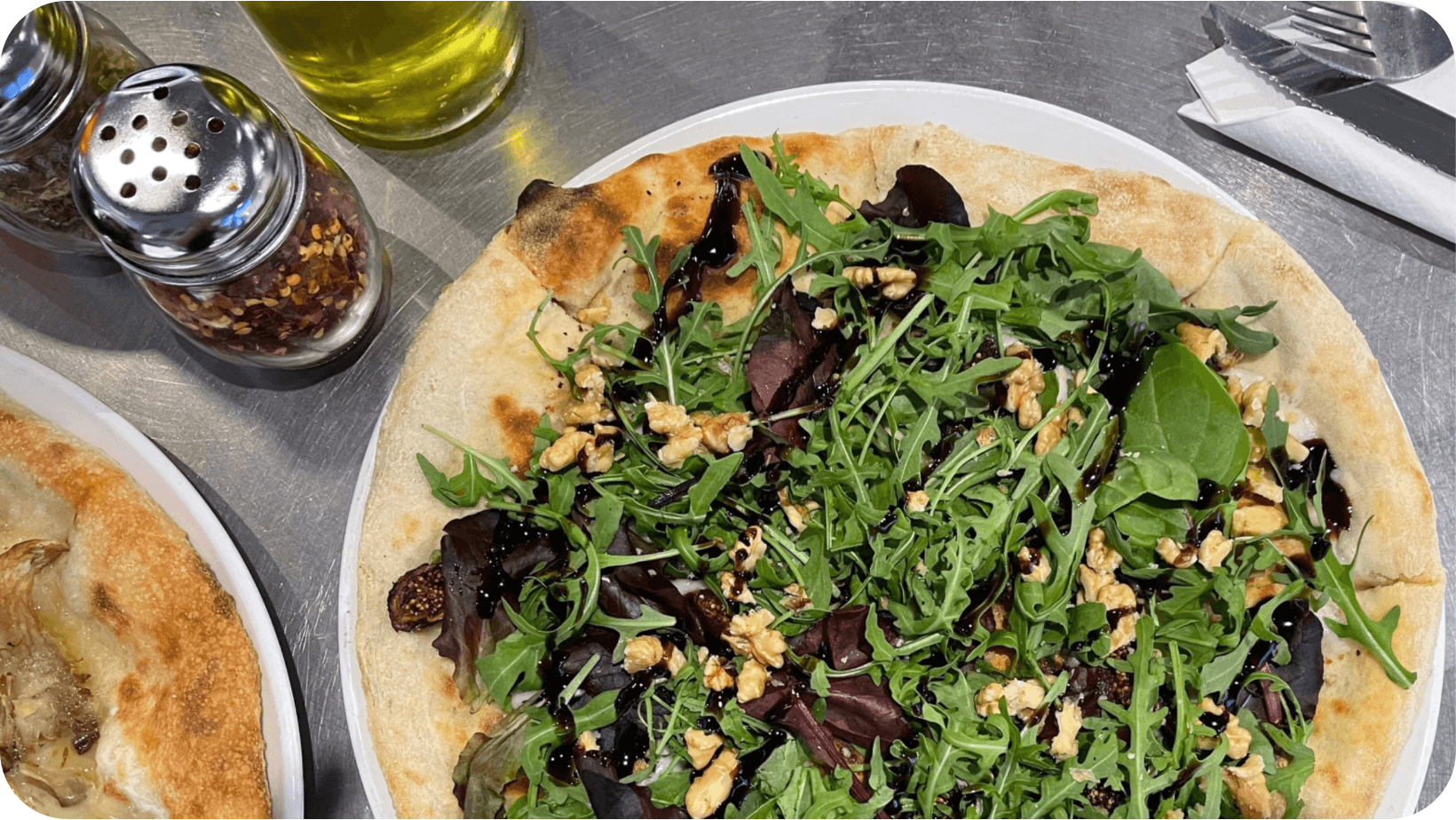 Vegan pizzas from V-izza topped with salad and balsamic 