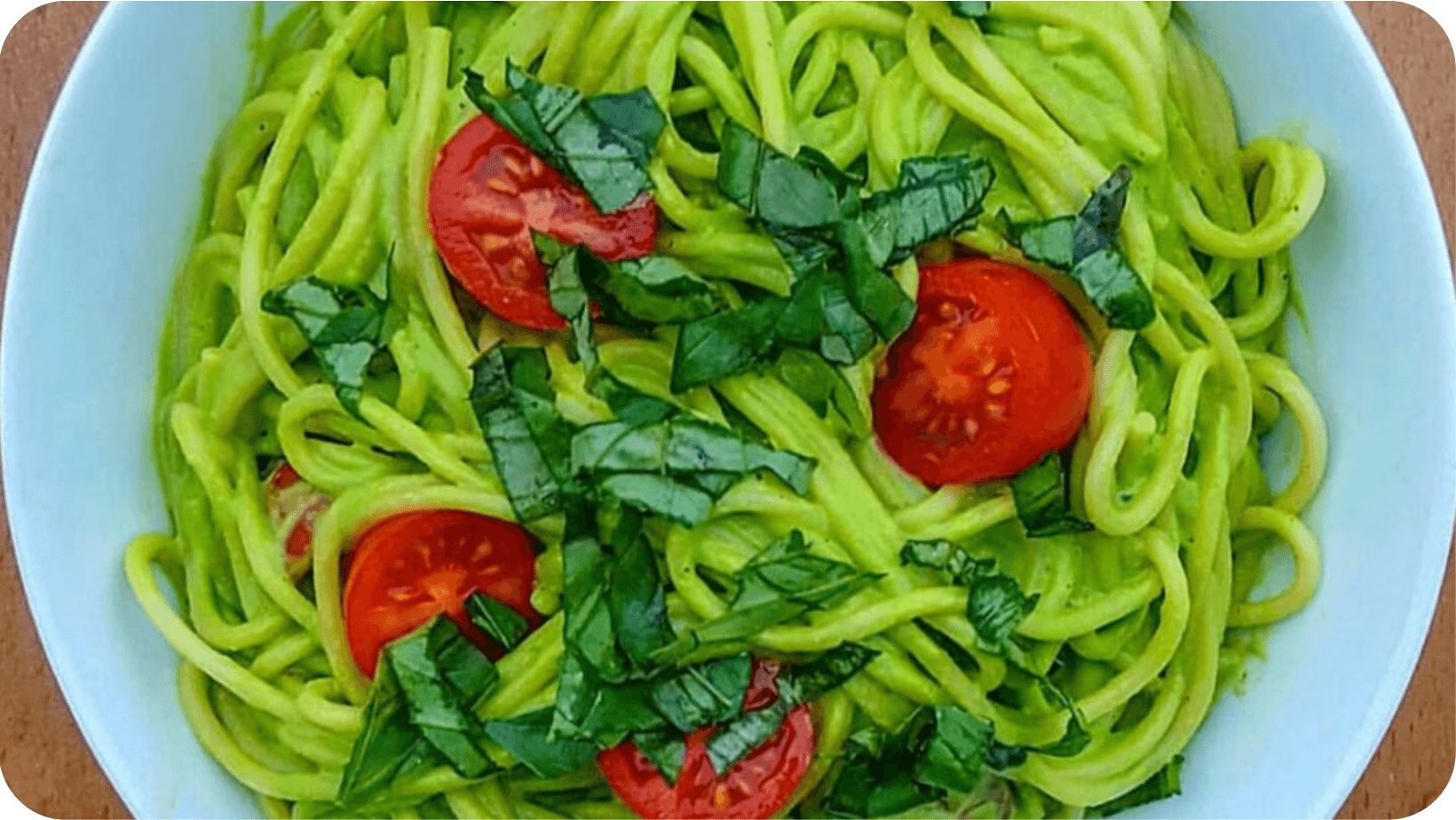 Bowl of spaghetti with tomatoes and chopped green herbs 