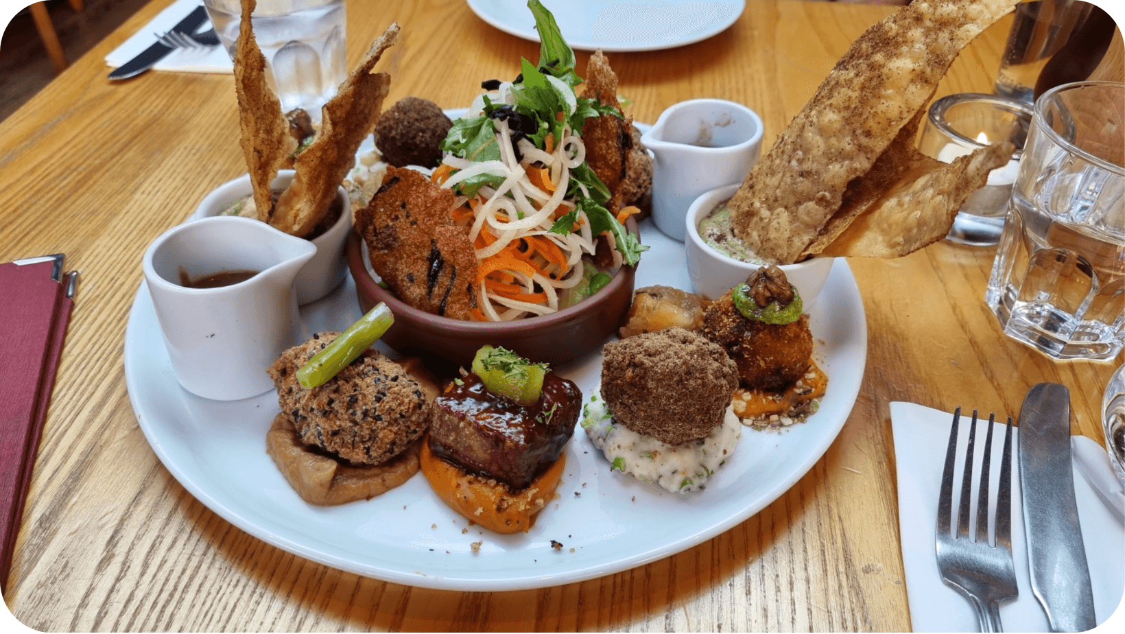 A variety of vegan starters on a white plate on a wooden table