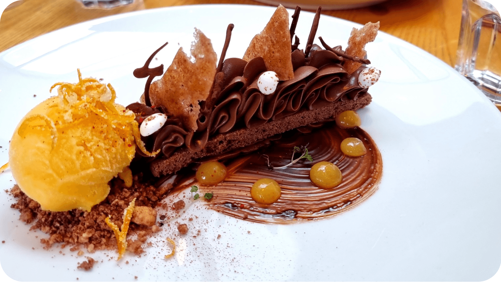 Slice of chocolate cake with a scoop of ice cream on a white plate