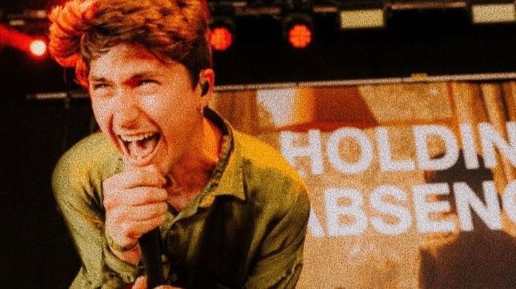 Lucas Woodland, lead vocalist from Holding Absence, singing into a microphone during a live performance