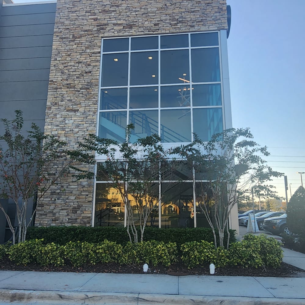 technician measuring large commercial insulated glass unit for storefront replacement in Orlando FL