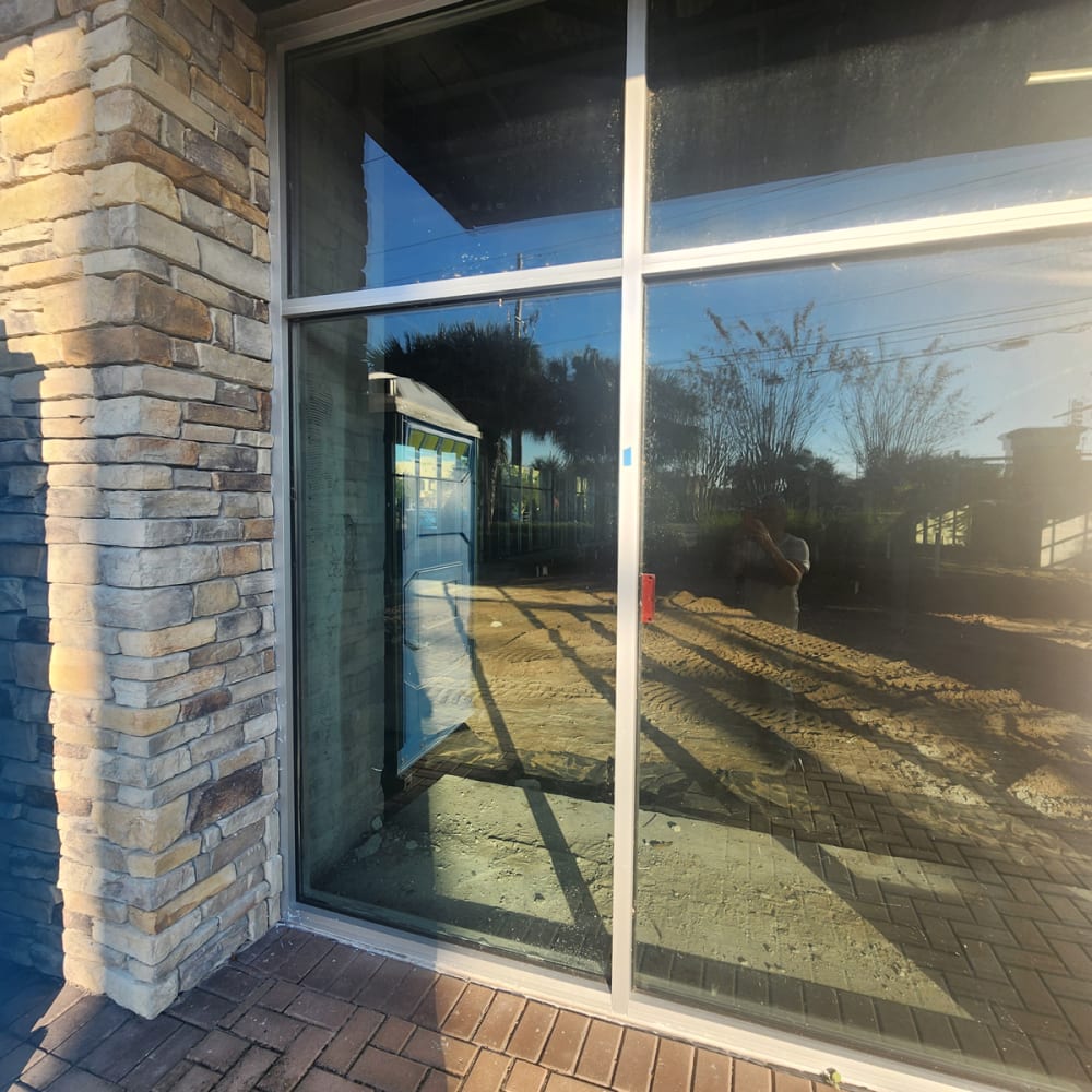 side by side comparison of fogged storefront insulated glass and new clear double pane replacement in Orlando business