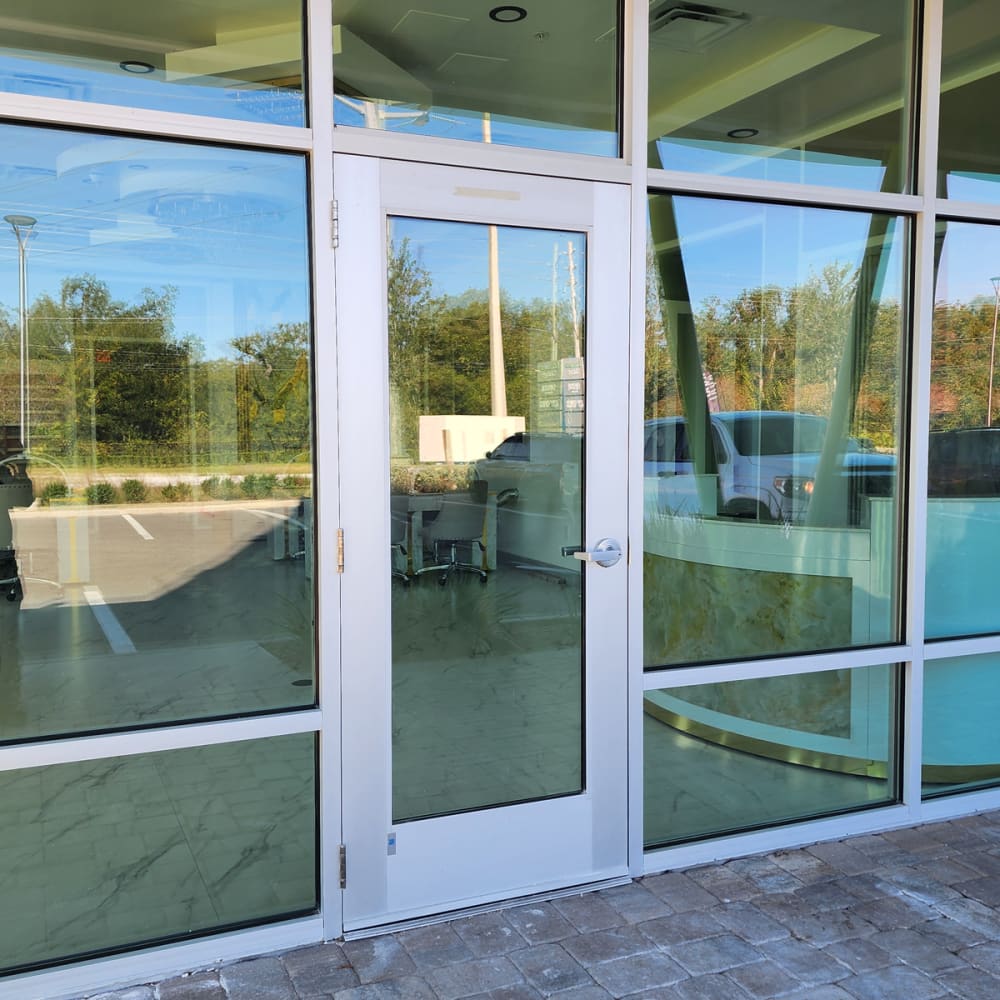 Technician cleaning broken glass, installing emergency board-up, and replacing window glass after break-in in Orlando