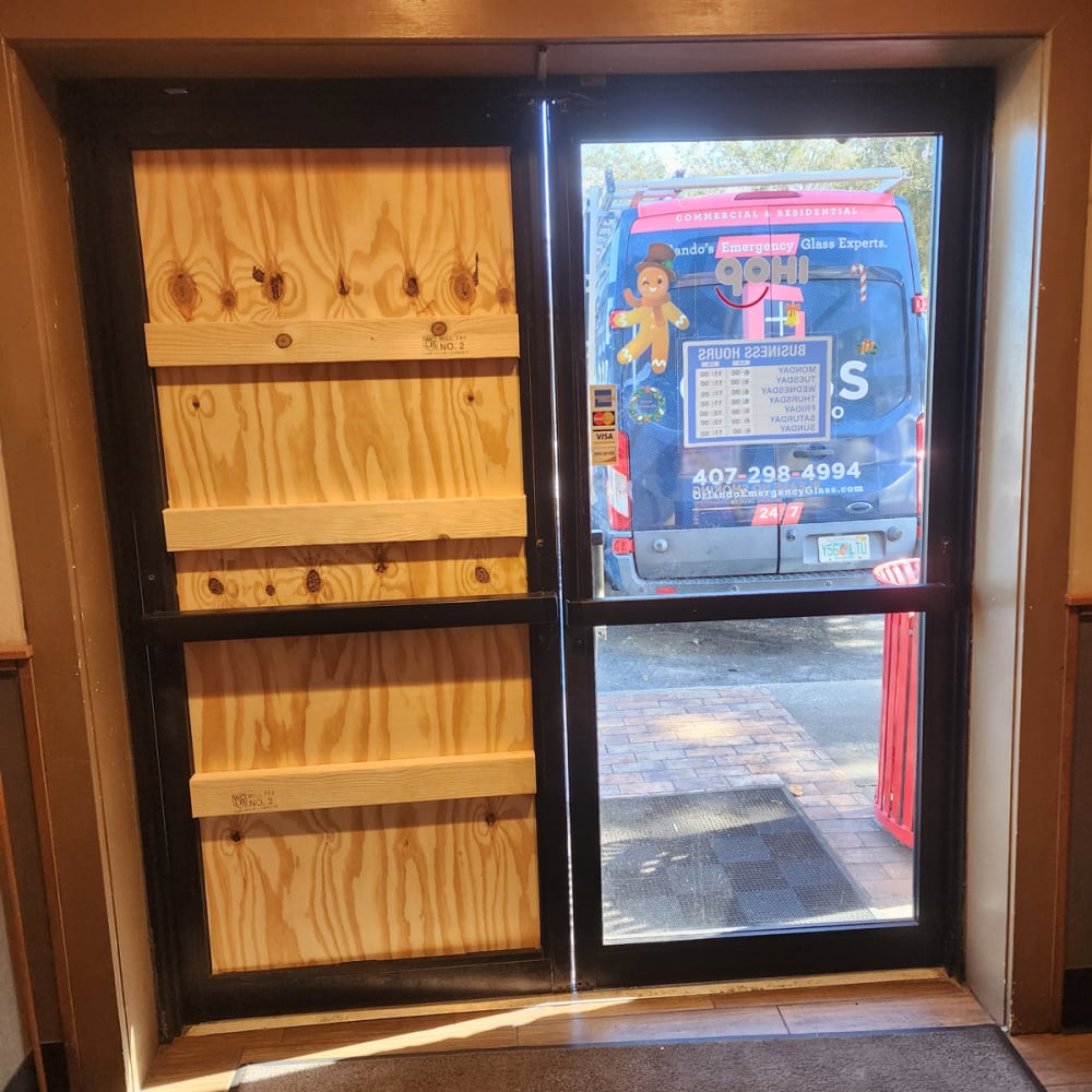 Boarded-up commercial storefront entrance in Central Florida showing same-day board-up service after vandalism or break-in