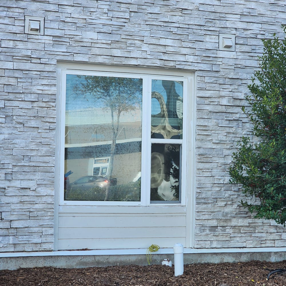 Sliding door, low window, and stair landing window in an Orlando home showing common locations that use safety glass