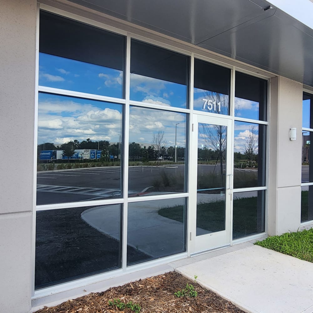 Commercial entry door in Orlando with a vertical vision lite and transom glass above the opening