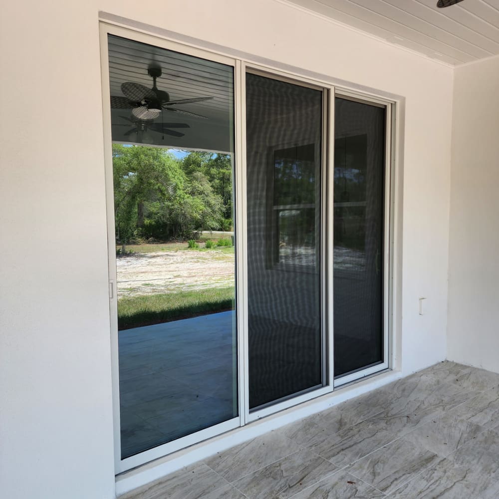 Sliding glass door and nearby home windows on an Orlando patio representing residential window and glass repair service