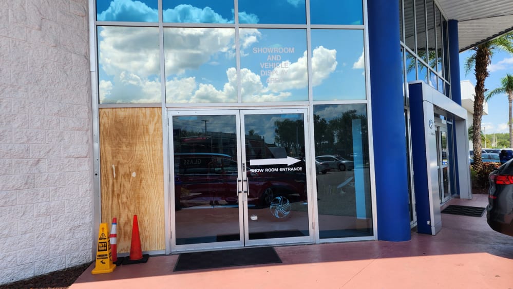 Emergency glass technician boarding up broken storefront door in Orlando after overnight break-in