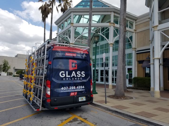 Glass Orlando service van parked in front of a Central Florida home and storefront advertising 24/7 window repair and glass replacement in Orlando