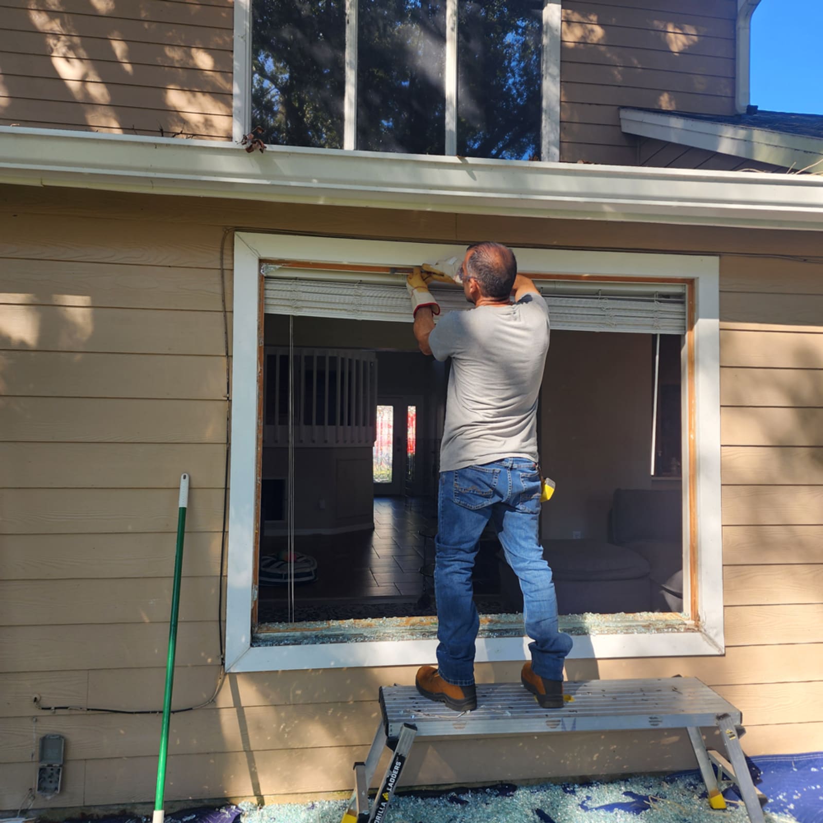 Glass Orlando technician installing replacement window glass with professional tools on a residential property