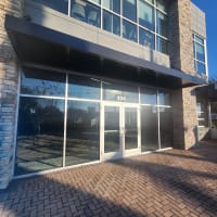 property manager using smoothly closing commercial glass door after closer and hinge repair in Sanford FL