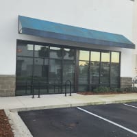 retail manager standing in front of new clear insulated storefront glass at Orlando shop