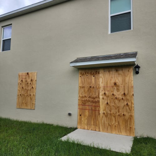 Shattered sliding glass door in Kissimmee secured with temporary board-up. Click to open in modal.