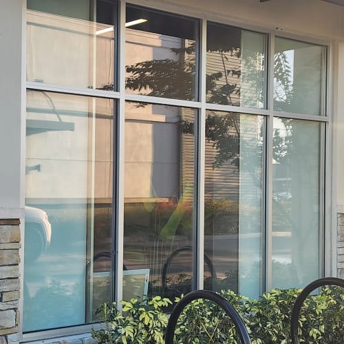 Technician replacing cracked storefront window glass at Orlando retail store. Click to open in modal.