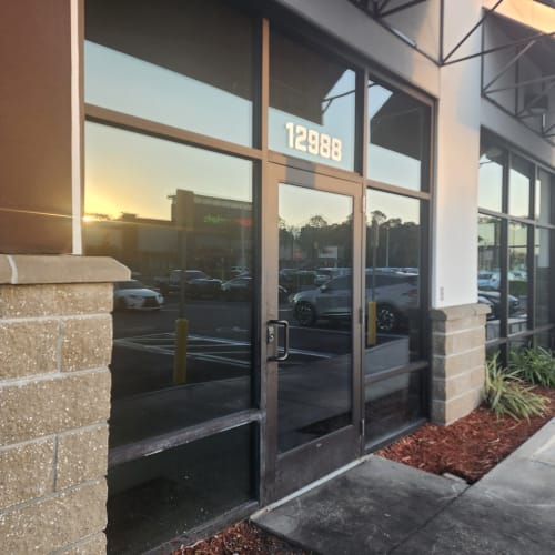 technician adjusting overhead door closer on storefront in Clermont FL. Click to open in modal.