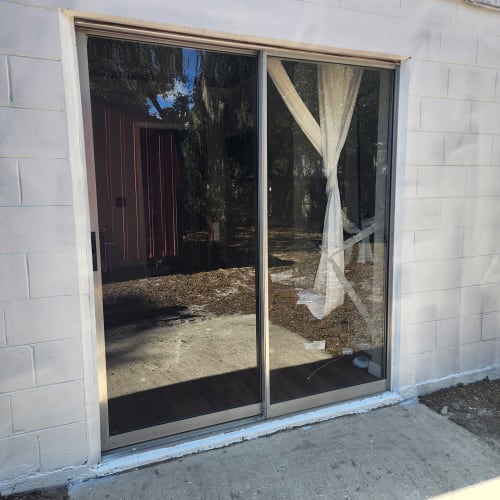 Emergency board-up on sliding glass door in Kissimmee home after break-in. Click to open in modal.