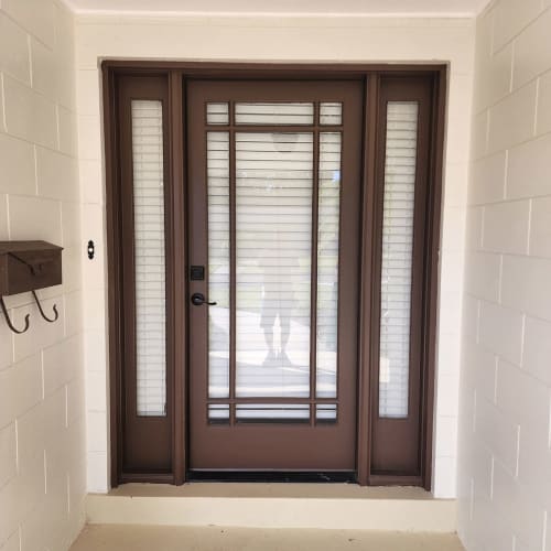 Custom-cut narrow sidelight window glass installed next to an entry door in an Orlando home.. Click to open in modal.