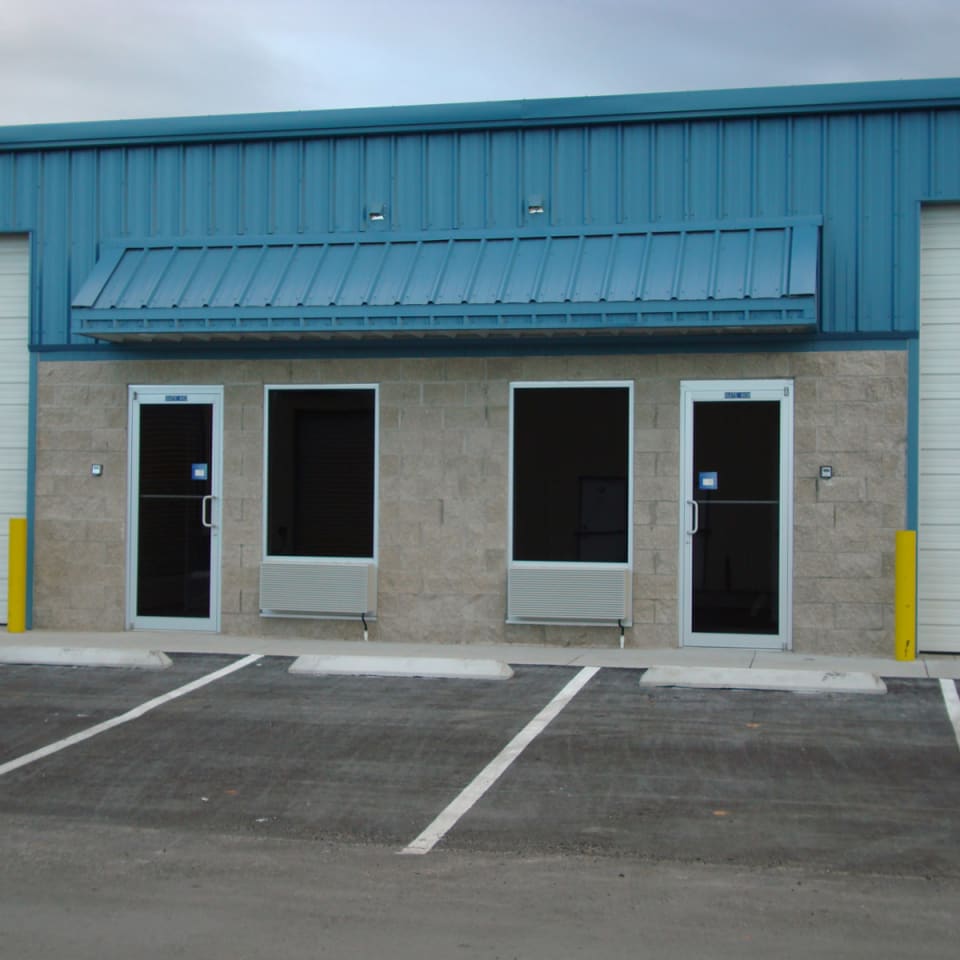 Commercial glass technician measuring a storefront frame for replacement in Orlando FL